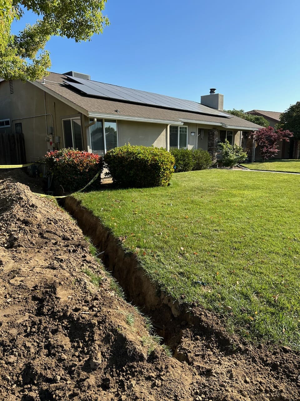 Underground trenching for electrical wiring in front yard of solar-powered home"<br />
