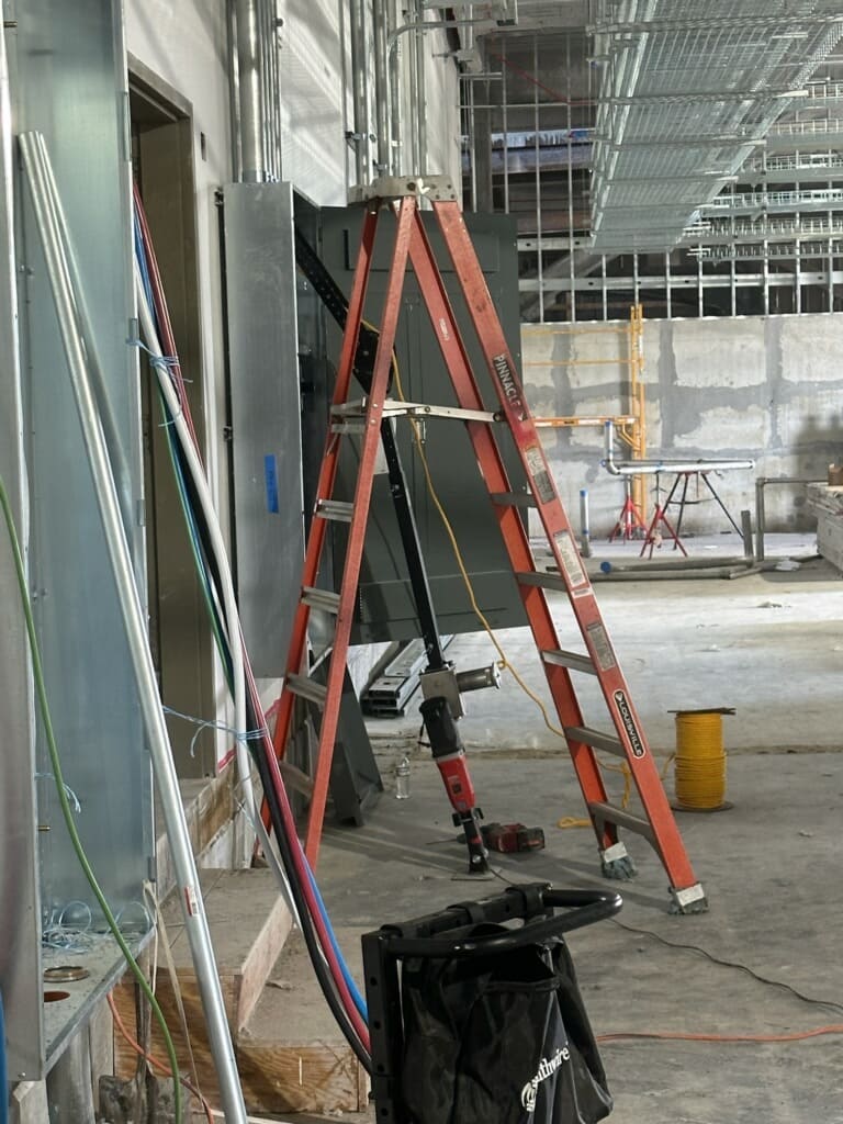 Commercial electrical panel installation at construction site with conduit wiring
