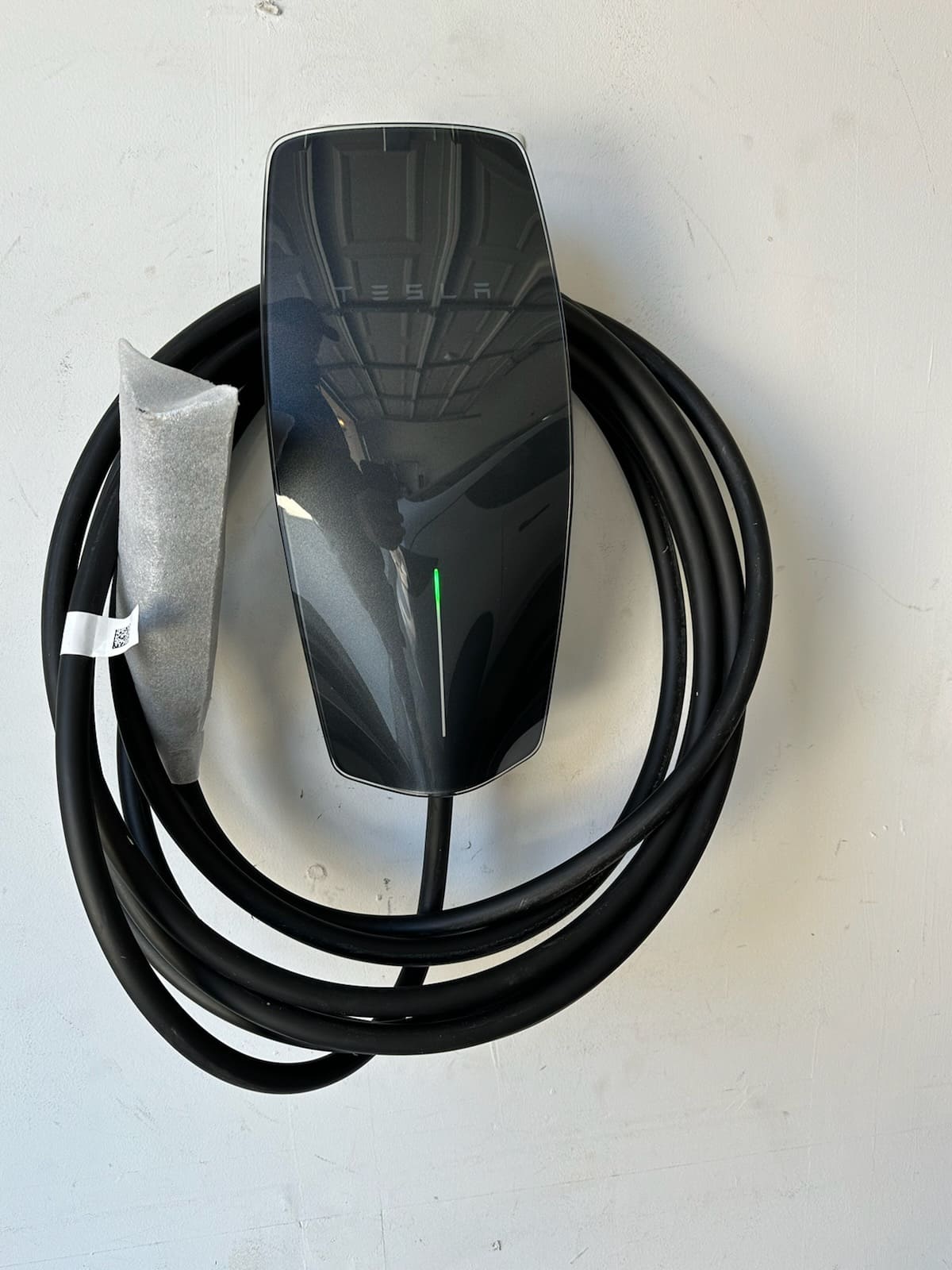 Tesla Wall Connector electric vehicle charger mounted on garage wall